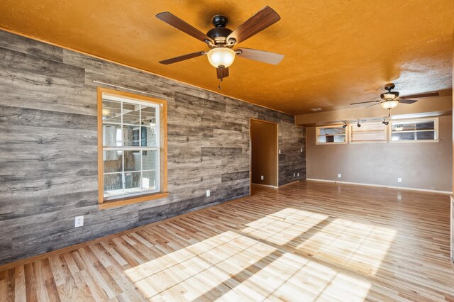 63219 Great River Rd, Jacobson, MN 55752 - unfurnished room featuring ceiling fan, wood-type flooring, and wooden walls