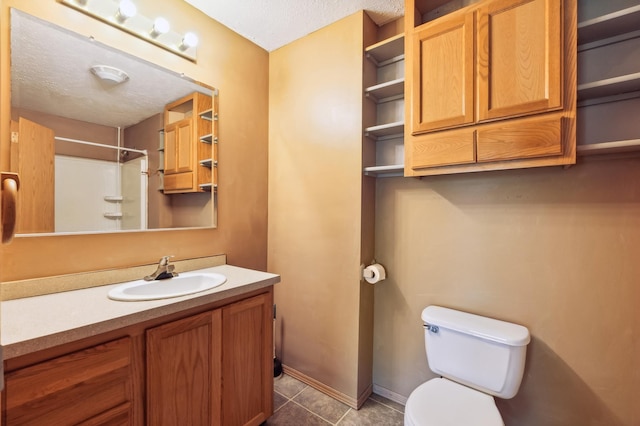 63219 Great River Rd, Jacobson, MN 55752 - bathroom featuring vanity, tile patterned floors, toilet, walk in shower, and a textured ceiling