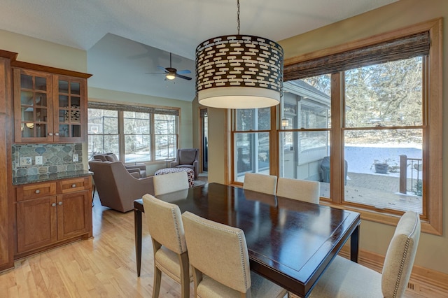 dining area with lofted ceiling, light hardwood / wood-style floors, and ceiling fan