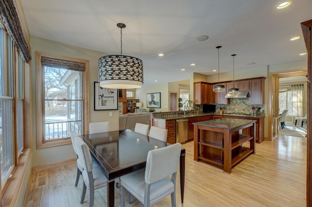 dining space featuring sink, a wealth of natural light, and light hardwood / wood-style flooring