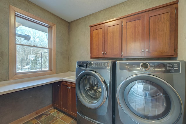 laundry room with cabinets and washing machine and clothes dryer