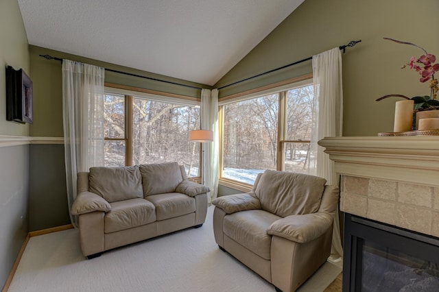 living room featuring a tiled fireplace, lofted ceiling, and light colored carpet