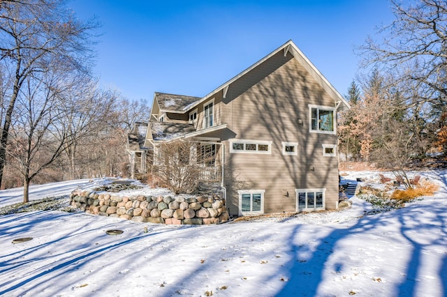 view of snow covered back of property