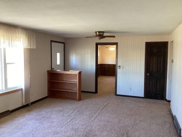 unfurnished bedroom with ceiling fan and light colored carpet