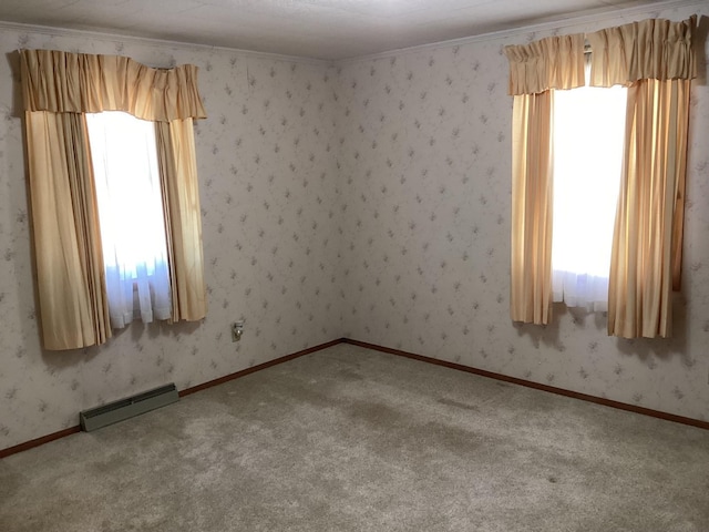 carpeted spare room featuring a textured ceiling, crown molding, a healthy amount of sunlight, and a baseboard radiator