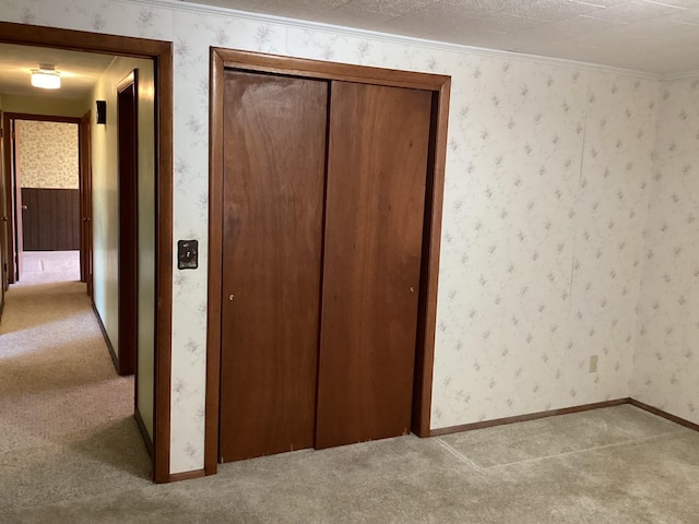 unfurnished bedroom featuring carpet, a textured ceiling, and a closet