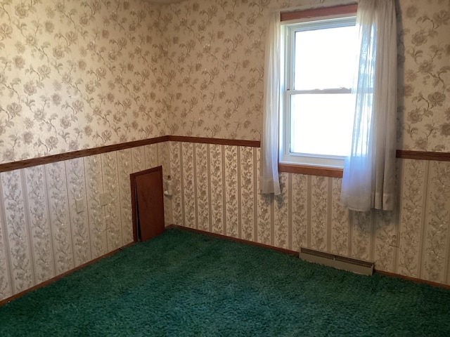 carpeted empty room with baseboard heating and a healthy amount of sunlight