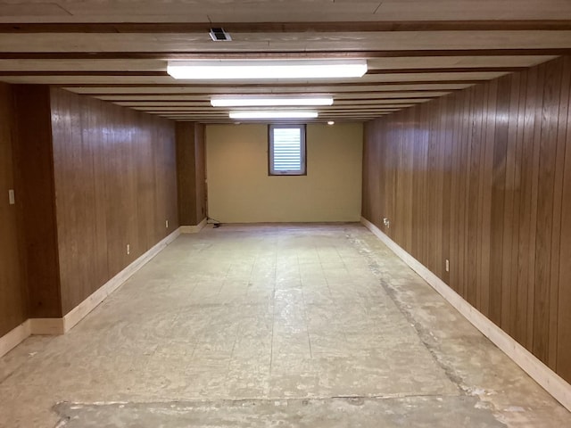 basement featuring wood walls