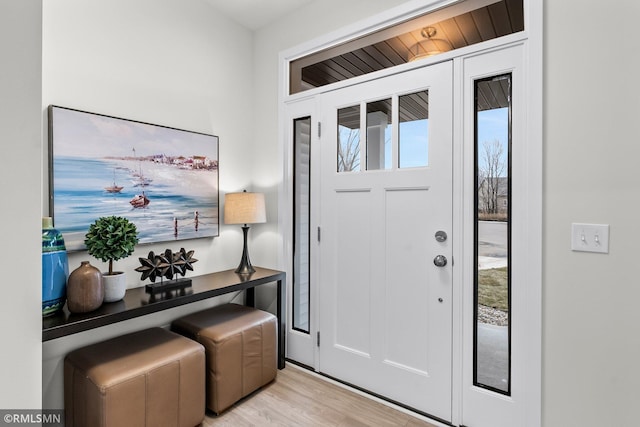 foyer entrance featuring light wood-type flooring and wood ceiling