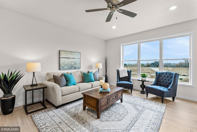 living room with ceiling fan and light wood-type flooring