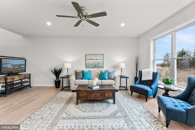 living room featuring light hardwood / wood-style floors and ceiling fan