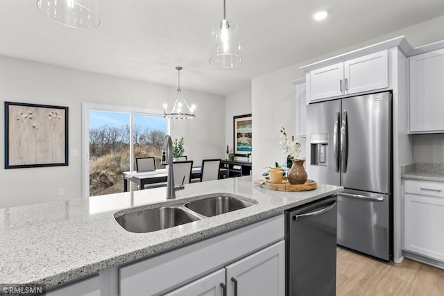 kitchen with white cabinets, light stone countertops, sink, and appliances with stainless steel finishes