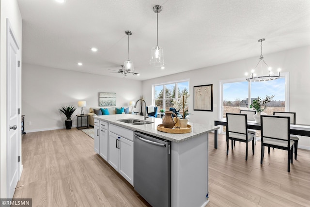 kitchen with dishwasher, a center island with sink, white cabinets, sink, and decorative light fixtures