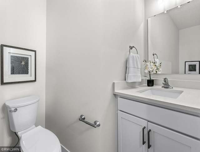 bathroom featuring a textured ceiling, vanity, and toilet