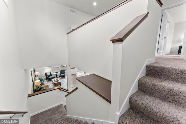 stairs featuring carpet flooring