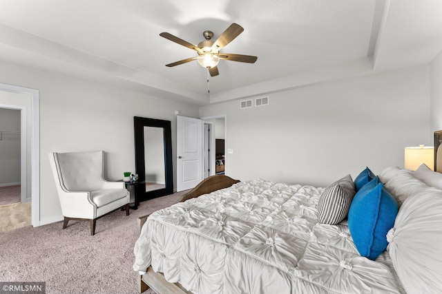 bedroom featuring carpet, a walk in closet, a closet, and ceiling fan