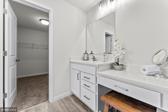 bathroom with vanity, a textured ceiling, and hardwood / wood-style flooring