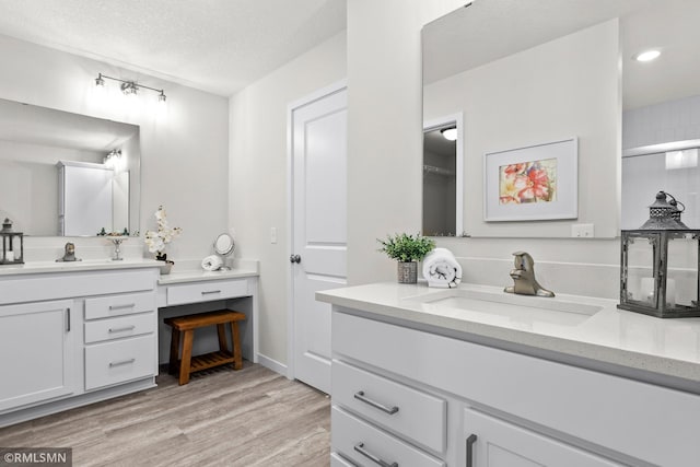 bathroom featuring vanity, a textured ceiling, and hardwood / wood-style flooring