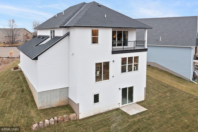 back of property with a balcony and a lawn