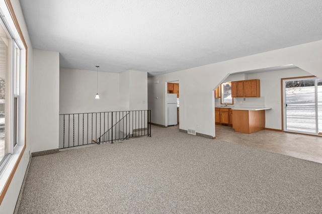 unfurnished living room featuring sink and light colored carpet