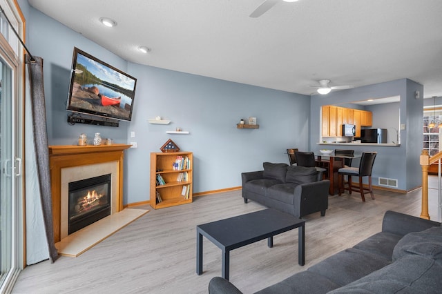 living room with ceiling fan and light hardwood / wood-style floors