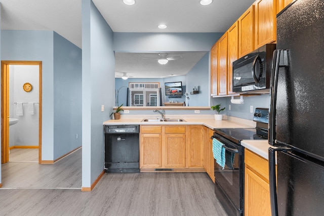 kitchen with sink, ceiling fan, black appliances, kitchen peninsula, and light wood-type flooring