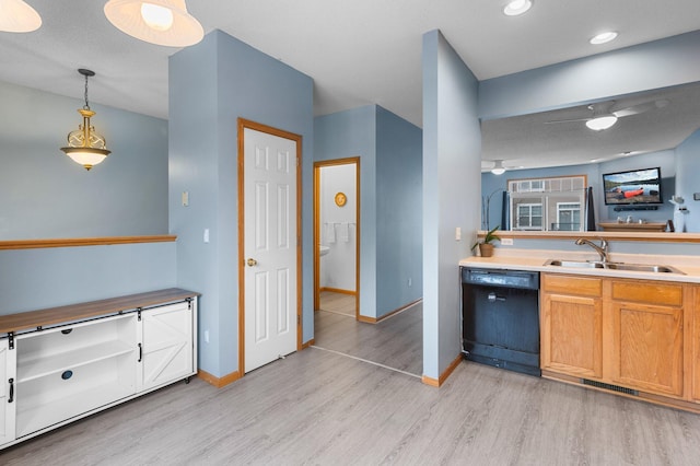 kitchen featuring dishwasher, sink, light hardwood / wood-style flooring, and decorative light fixtures