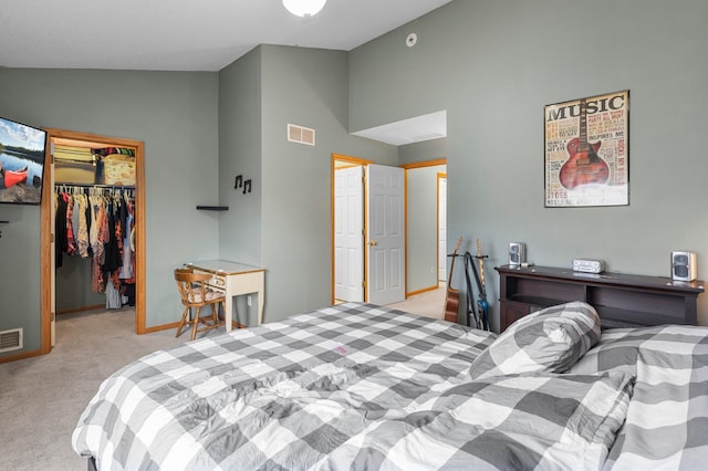 bedroom with a walk in closet, lofted ceiling, light carpet, and a closet