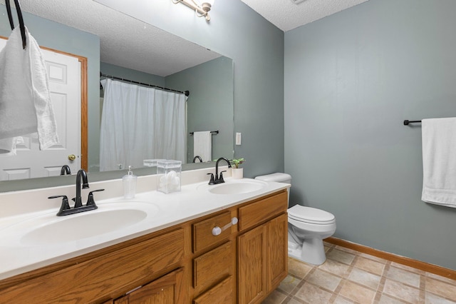 bathroom featuring vanity, a textured ceiling, and toilet