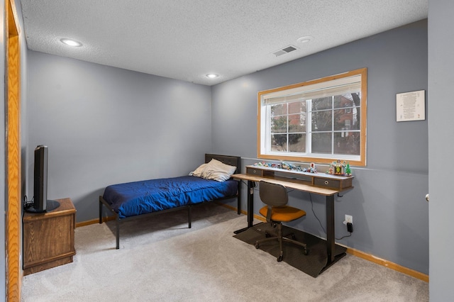 bedroom featuring light colored carpet and a textured ceiling