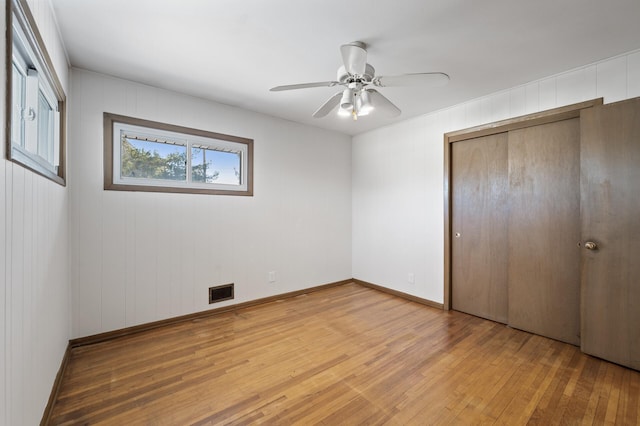 unfurnished bedroom with hardwood / wood-style flooring, a closet, and ceiling fan