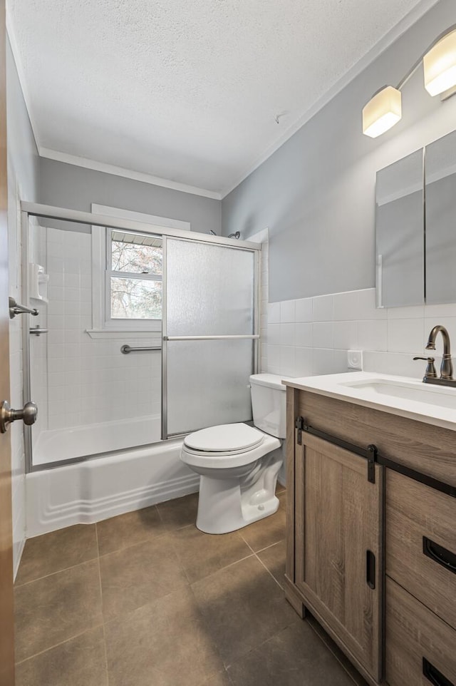 full bathroom featuring tile patterned flooring, vanity, bath / shower combo with glass door, tile walls, and toilet