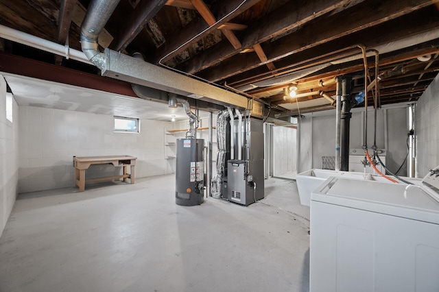 basement featuring sink, heating unit, water heater, and independent washer and dryer