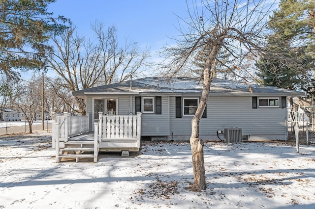 snow covered property featuring cooling unit and a wooden deck