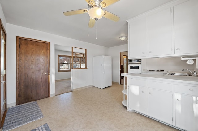 kitchen featuring sink, ceiling fan, white cabinetry, and white appliances