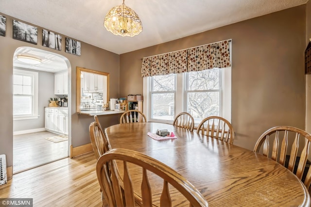 dining space featuring a notable chandelier and light hardwood / wood-style floors