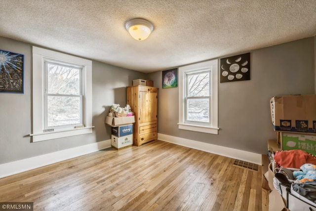 interior space featuring light hardwood / wood-style floors and a textured ceiling