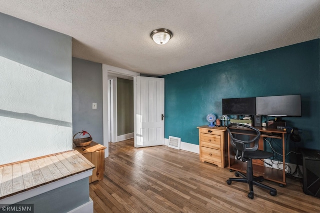 office with a textured ceiling and dark hardwood / wood-style flooring