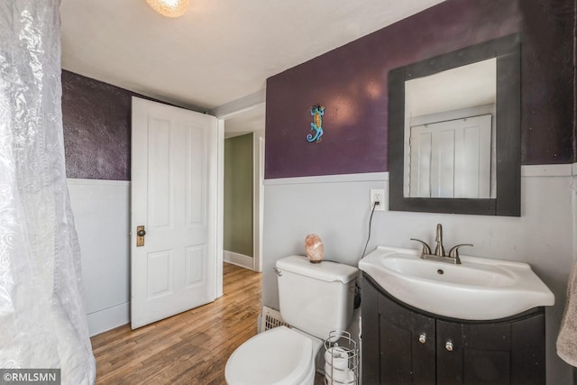 bathroom featuring wood-type flooring, vanity, and toilet