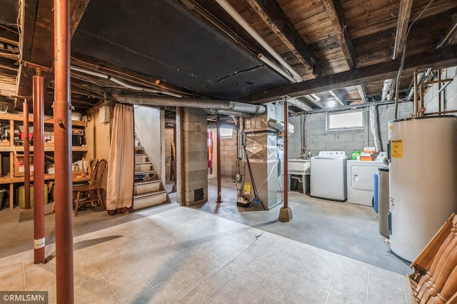 basement featuring washer and clothes dryer, electric water heater, and heating unit