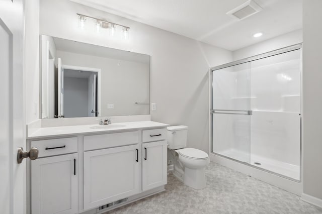 bathroom with vanity, toilet, and a shower with door