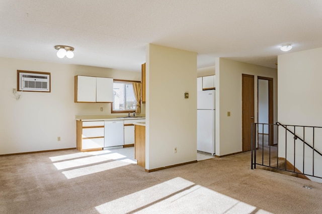 kitchen featuring a wall mounted AC, light carpet, white cabinets, and white appliances