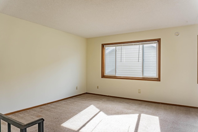 unfurnished room featuring carpet flooring and a textured ceiling