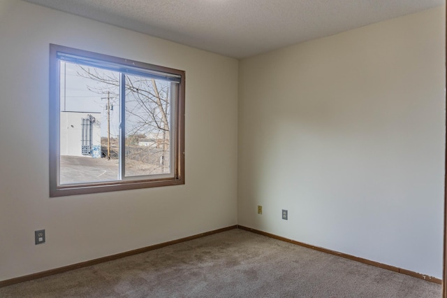 carpeted spare room featuring a textured ceiling