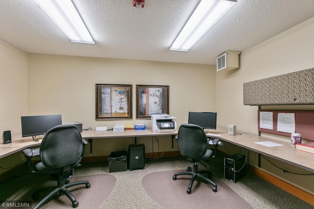 carpeted home office with a textured ceiling