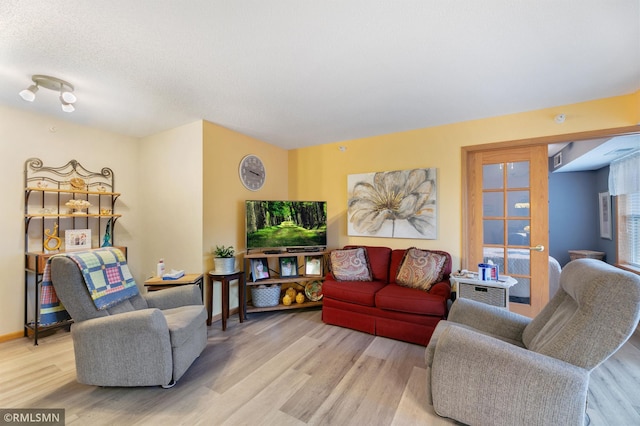 living room with a textured ceiling and light wood-type flooring