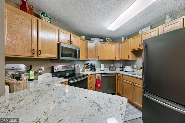 5650 Boone Ave N Unit 321, New Hope, MN 55428 - kitchen with stainless steel appliances, a textured ceiling, light stone counters, and a sink
