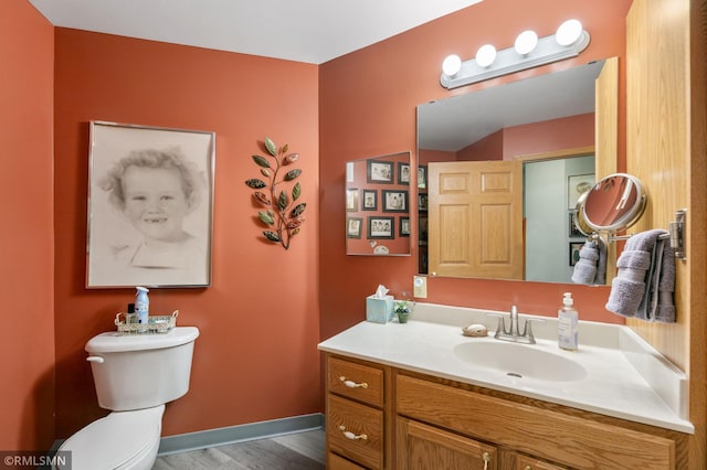 5650 Boone Ave N Unit 321, New Hope, MN 55428 - bathroom featuring toilet, vanity, wood finished floors, and baseboards