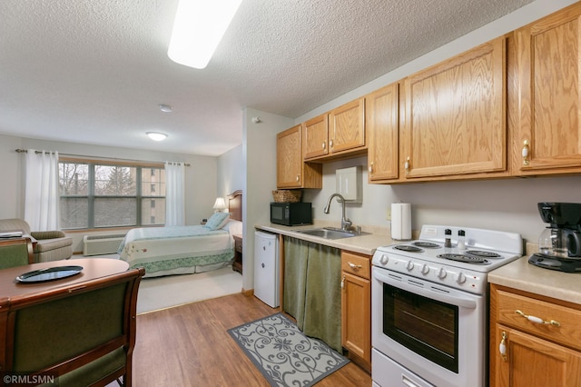 5650 Boone Ave N Unit 321, New Hope, MN 55428 - kitchen with white appliances, a sink, open floor plan, light countertops, and light wood-style flooring