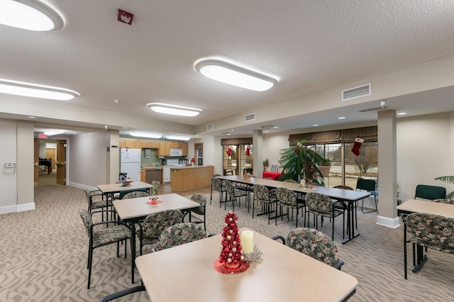5650 Boone Ave N Unit 321, New Hope, MN 55428 - dining space featuring light carpet and a textured ceiling
